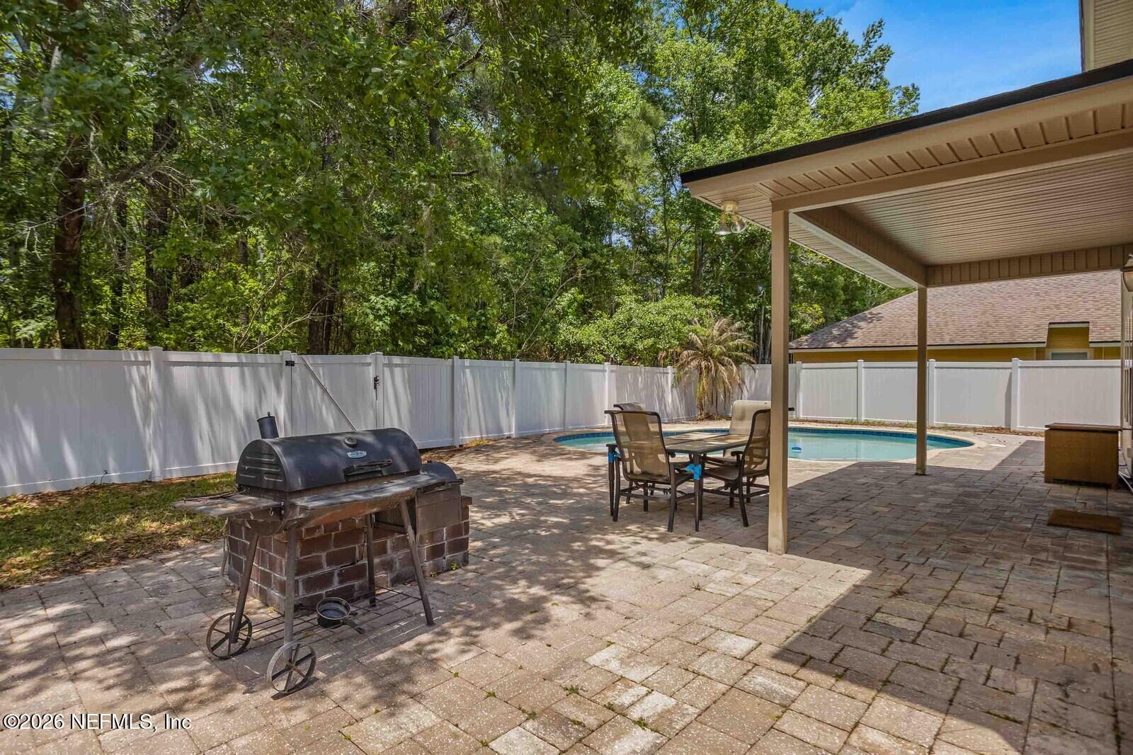 652 Spanish Wells Road Jacksonville, FL 32218 - Photo 30 of 32 a backyard of a house with table and chairs