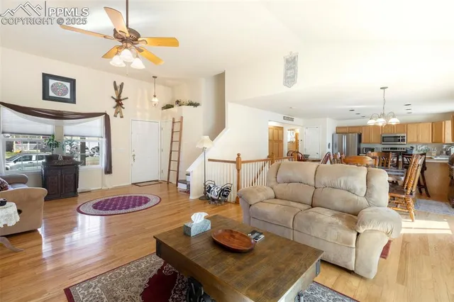 a living room with furniture kitchen view and a chandelier