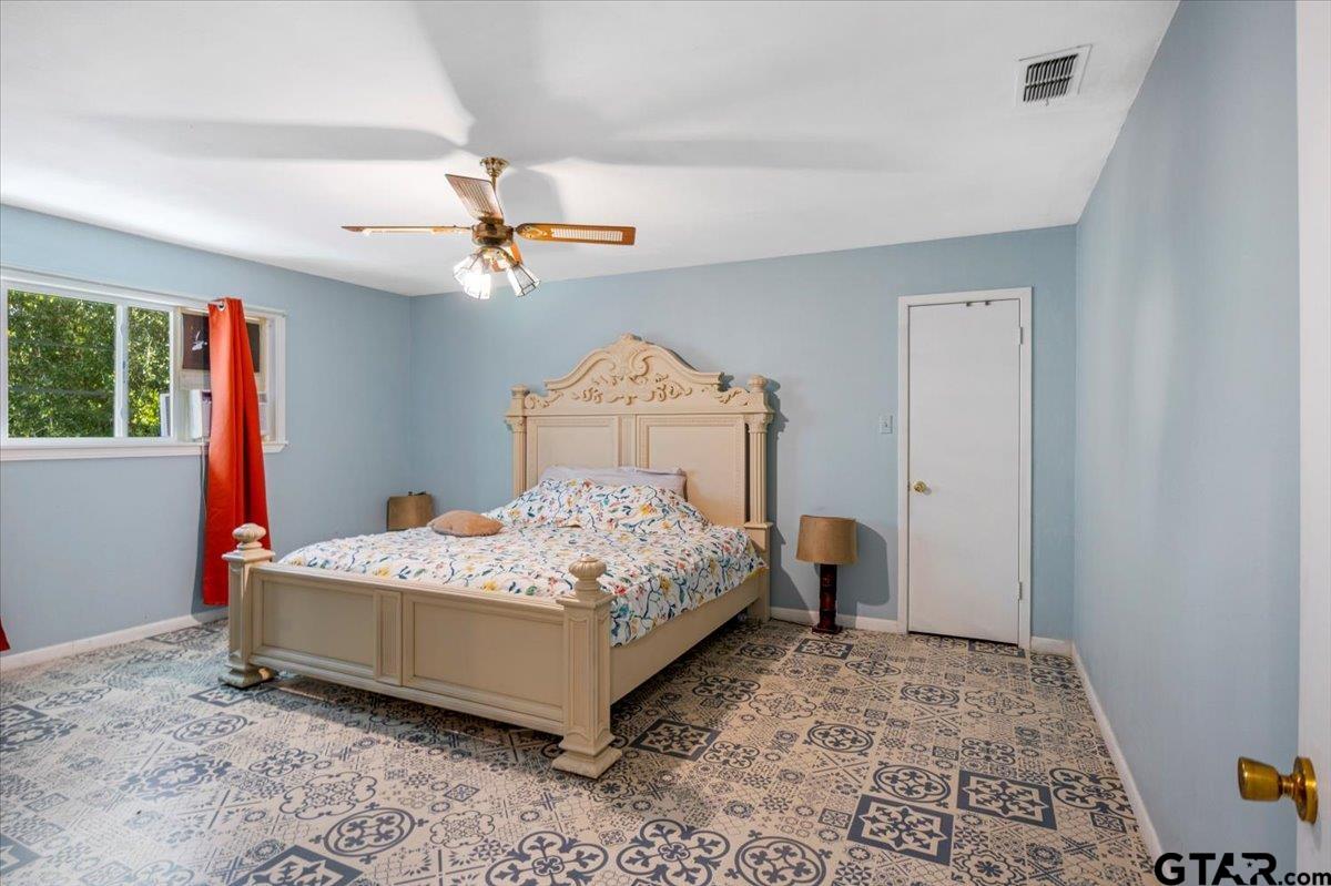 3109 West Shaw Street Tyler, TX 75701 - Photo 17 of 27 a bedroom with a bed and a chandelier