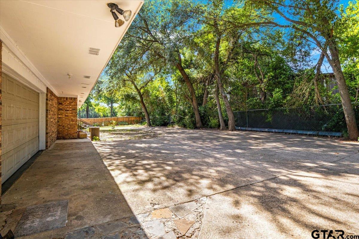 3109 West Shaw Street Tyler, TX 75701 - Photo 20 of 27 a view of a backyard with large trees