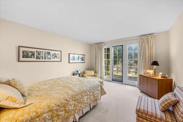 a spacious bedroom with a bed and glass window