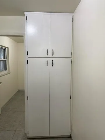 an empty room with chandelier fan and windows