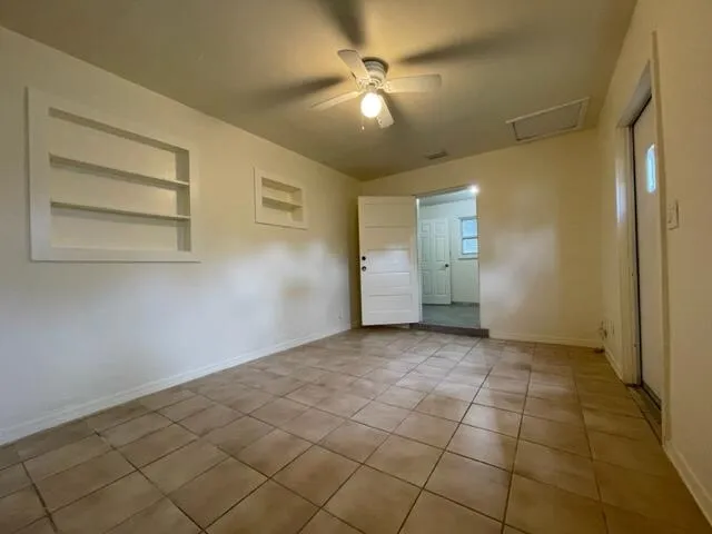 a view of an empty room with a chandelier fan