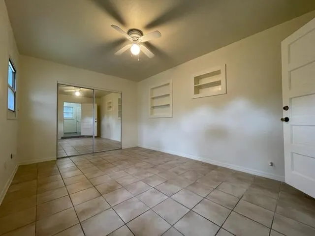 an empty room with fan and entrance