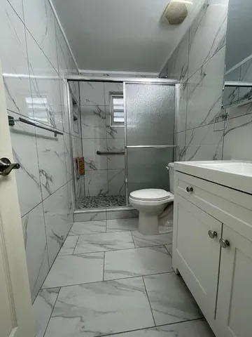 a white toilet sitting next to a shower
