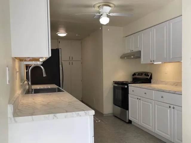 a kitchen with kitchen island a sink stainless steel appliances and cabinets