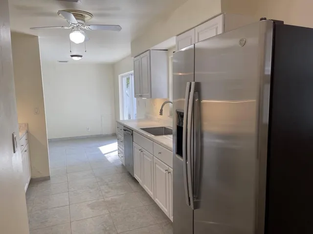 a kitchen with kitchen island a counter top space appliances and a refrigerator
