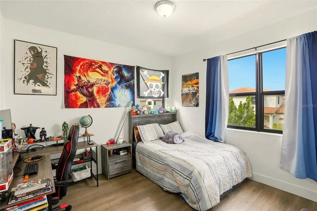 a bedroom with a bed and wooden floor