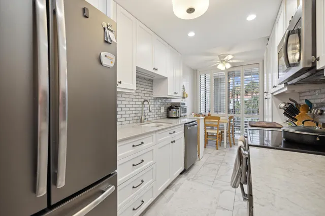 a kitchen with stainless steel appliances granite countertop a refrigerator and a stove top oven