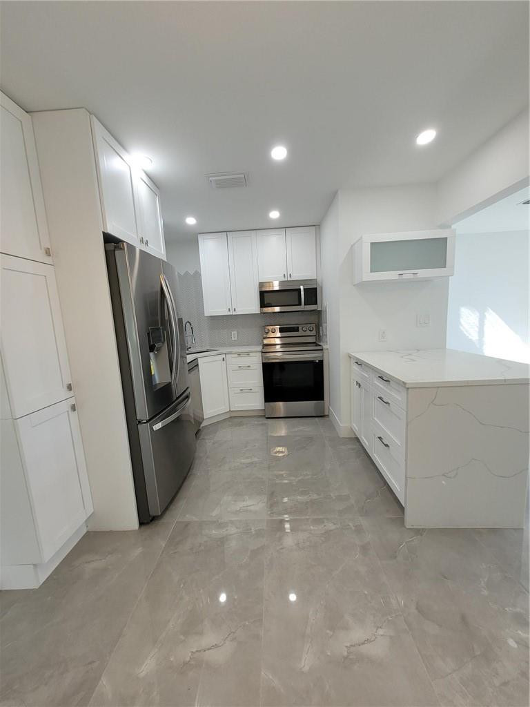 6041 Southwest 17th Street Miami, FL 33155 - Photo 4 of 26 a kitchen with stainless steel appliances a refrigerator sink and stove