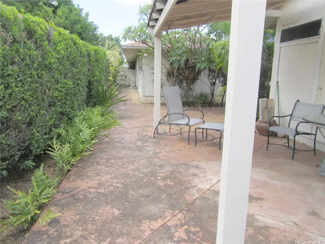 a view of a patio with table and chairs and potted plants