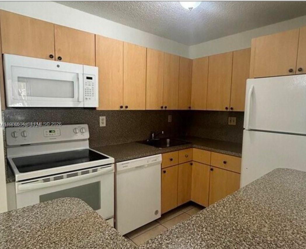 15520 Southwest 80th Street, Unit B103 Miami, FL 33193 - Photo 2 of 7 a kitchen with a sink cabinets and appliances
