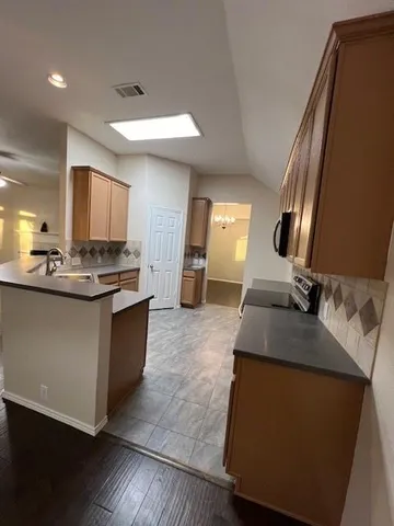 a kitchen with kitchen island granite countertop a sink stove and refrigerator