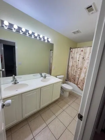 a spacious bathroom with a double vanity sink mirror and toilet