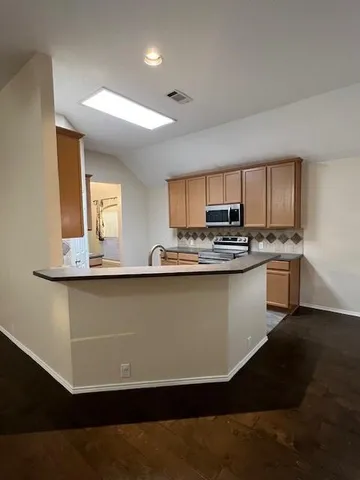 a kitchen with a sink a microwave and cabinets