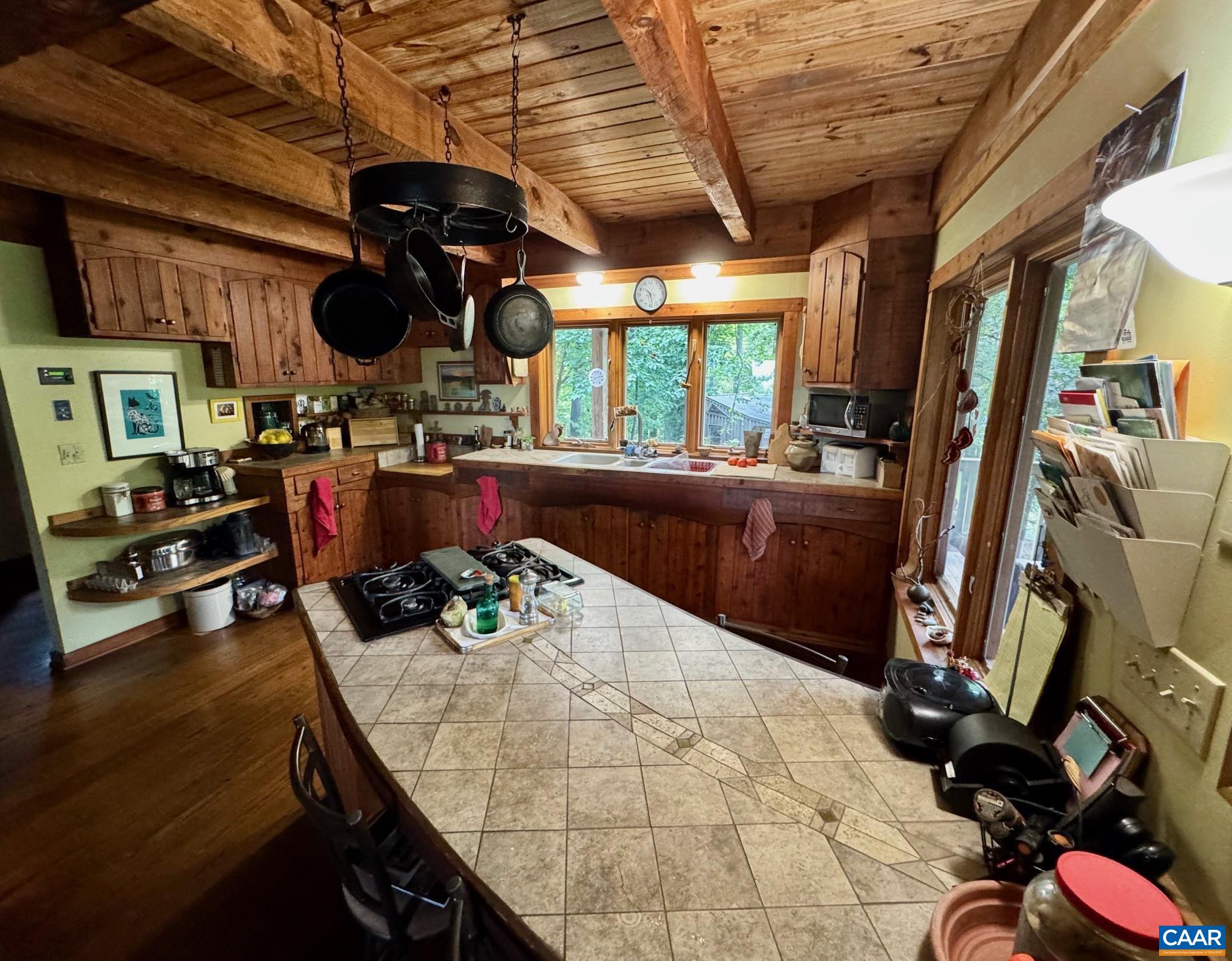 1950 Locust Hollow Road Charlottesville, VA 22903 - Photo 19 of 54 a kitchen with a stove a refrigerator and a dining table with wooden floor