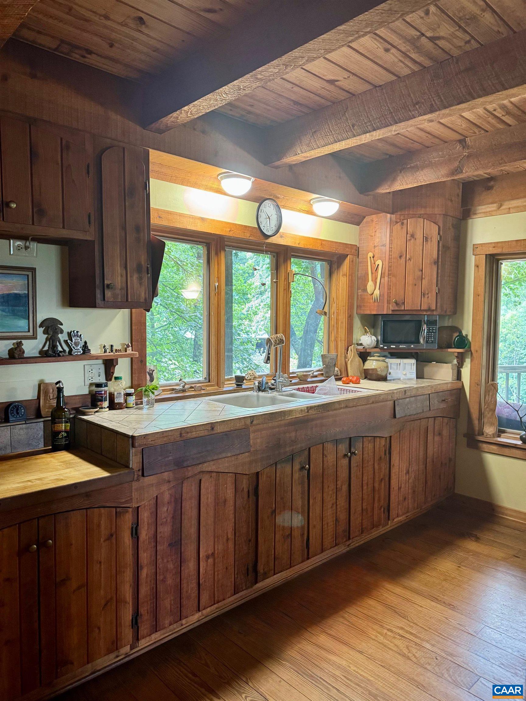1950 Locust Hollow Road Charlottesville, VA 22903 - Photo 20 of 54 a kitchen with stainless steel appliances wooden cabinets a stove a sink and a large window