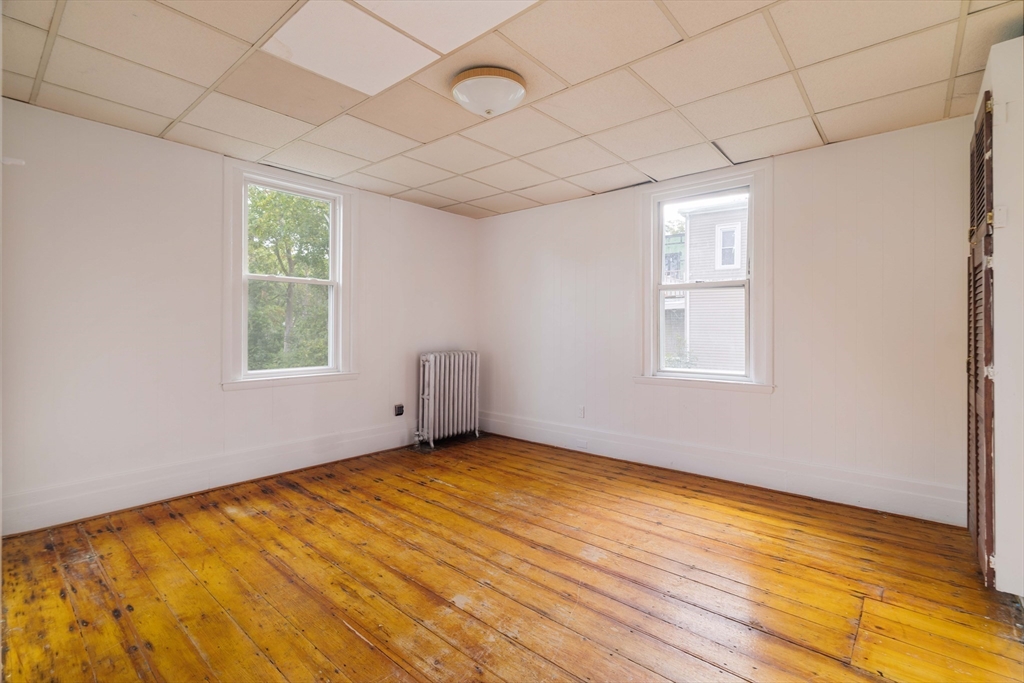 18 Westminster Avenue Boston, MA 02119 - Photo 16 of 37 a view of an empty room with wooden floor and a window