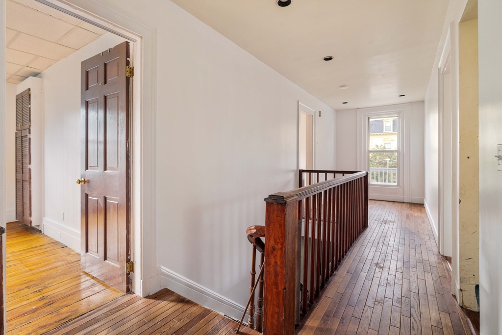 18 Westminster Avenue Boston, MA 02119 - Photo 18 of 37 a view of a hallway with wooden floor and staircase