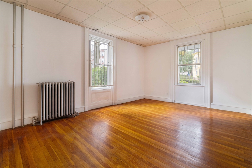 18 Westminster Avenue Boston, MA 02119 - Photo 23 of 37 an empty room with wooden floor and windows