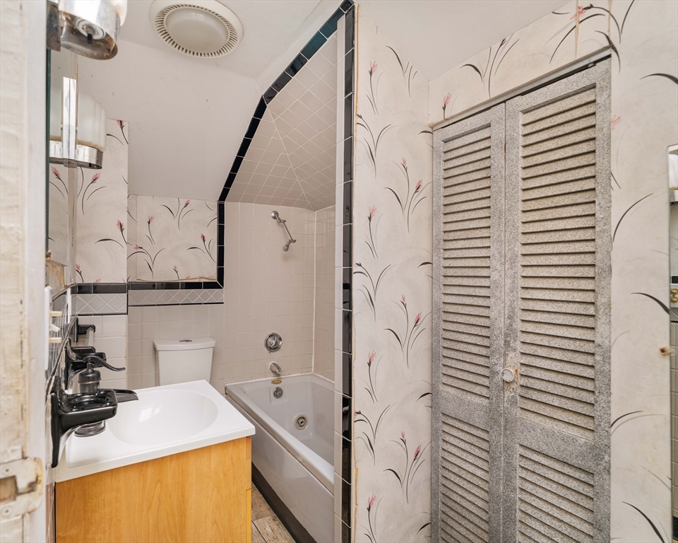 18 Westminster Avenue Boston, MA 02119 - Photo 29 of 37 a bathroom with a granite countertop sink and a shower