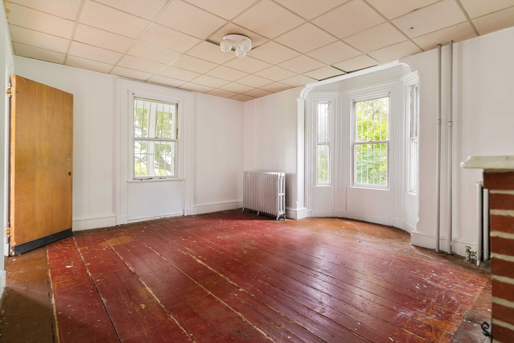18 Westminster Avenue Boston, MA 02119 - Photo 6 of 37 a view of an empty room with a window and wooden floor