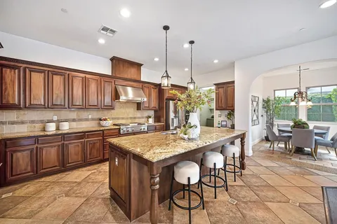 a kitchen with stainless steel appliances granite countertop a sink and dishwasher with white cabinets