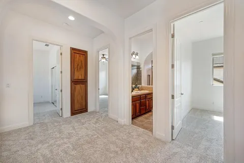 a spacious bedroom that has a bed and a chandelier