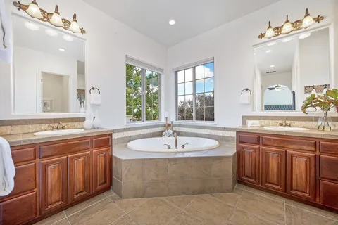 a view of a house with swimming pool lawn chairs and a fire pit
