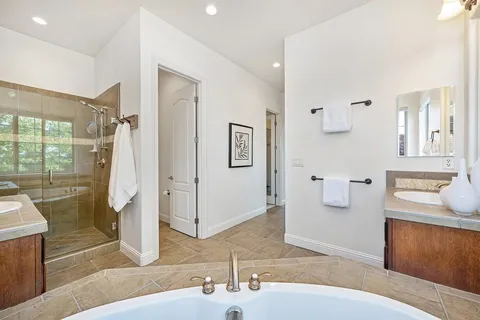 a view of a house with a garden and large trees