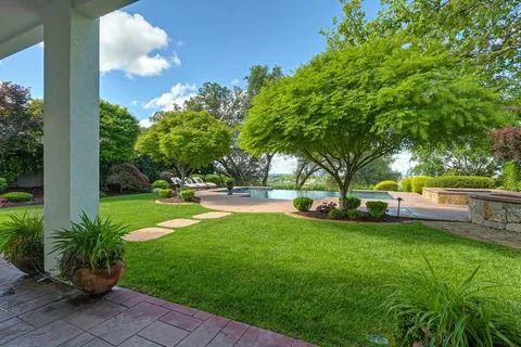 a view of a house with backyard and a tree