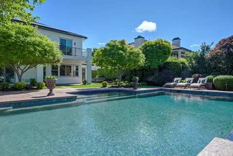 a view of a house with backyard and sitting area