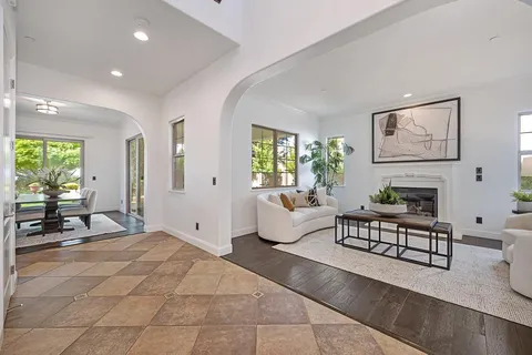 a living room with furniture a fireplace with walls and a large window