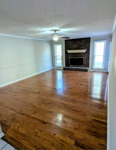 a view of empty room with wooden floor and fireplace