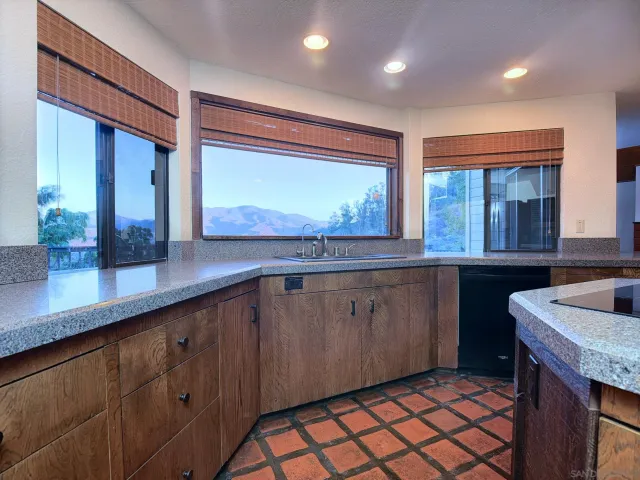 a kitchen with stainless steel appliances granite countertop a sink and a large window