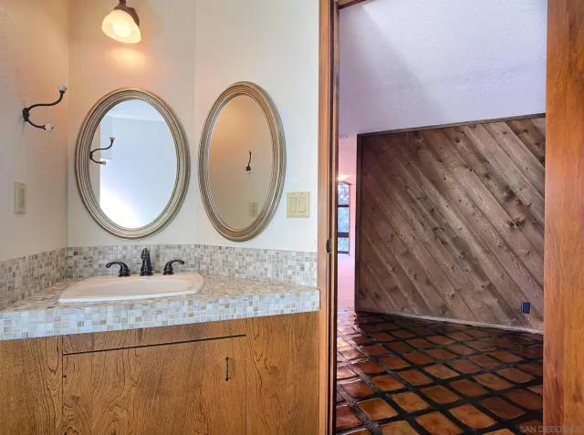 a bathroom with a granite countertop sink and a mirror
