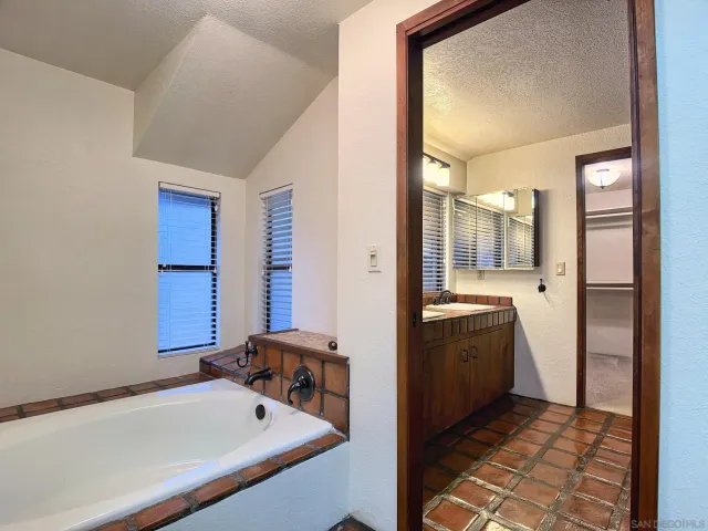 a bathroom with a tub sink and mirror