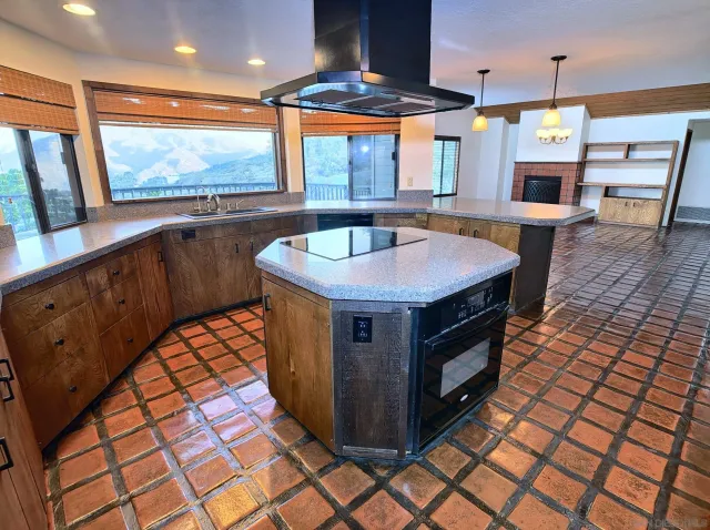 a kitchen with stainless steel appliances granite countertop a stove a sink and a large window