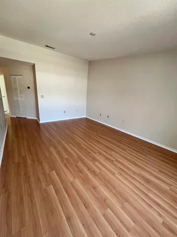 a view of an empty room with wooden floor