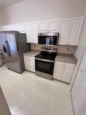 a kitchen with cabinets and steel appliances