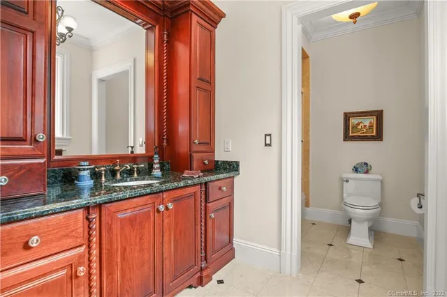 a bathroom with a granite countertop sink mirror vanity and toilet