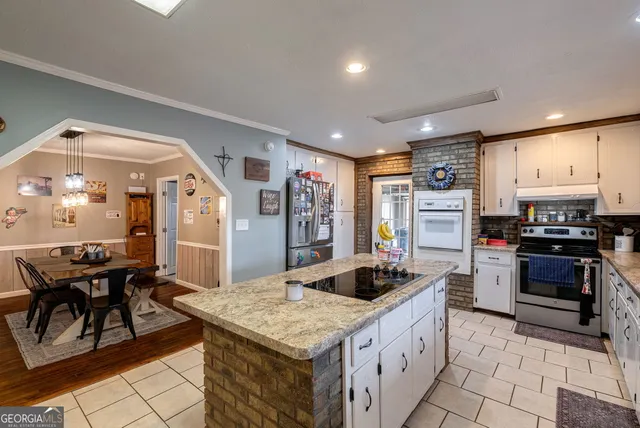 a kitchen with stainless steel appliances granite countertop a refrigerator a stove a sink and a refrigerator