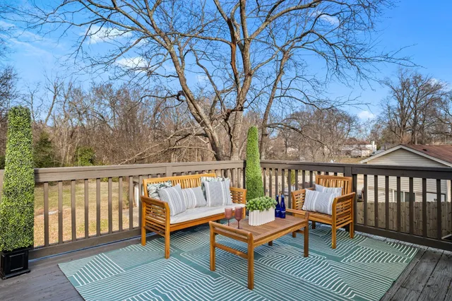 a balcony with wooden floor and outdoor seating