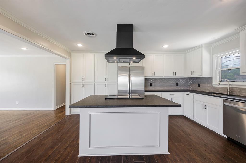 2323 Sutter Street Dallas, TX 75216 - Photo 9 of 30 Kitchen featuring dark hardwood / wood-style flooring, stainless steel appliances, island exhaust hood, a center island, and ornamental molding