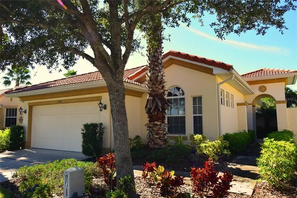 a front view of a house with a yard and a garden