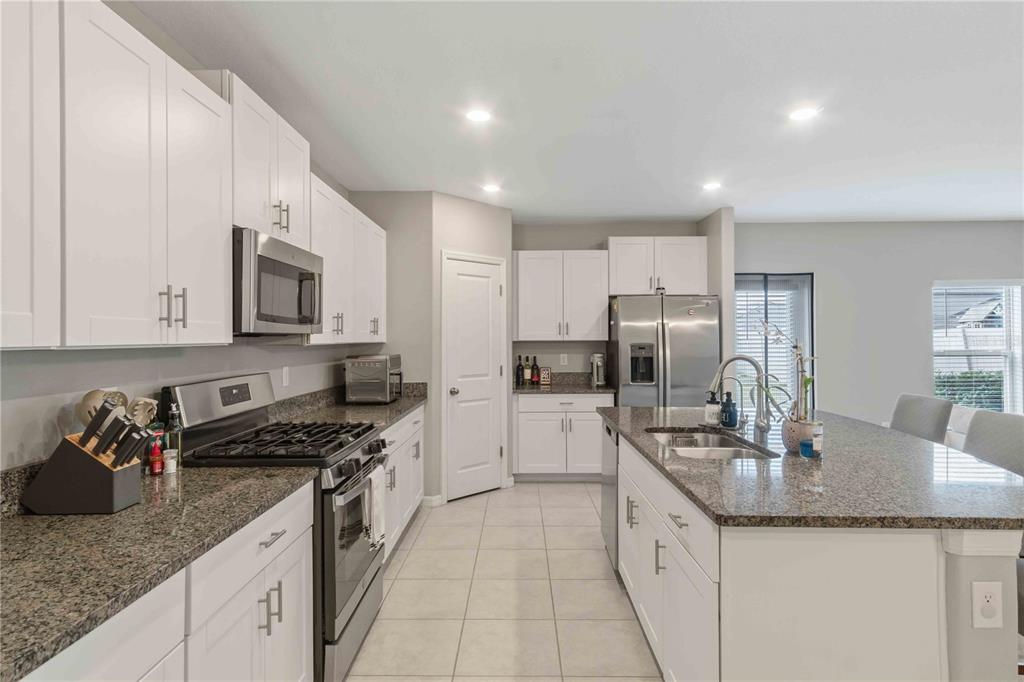 9440 Lemon Drop Loop Sun City Center, FL 33573 - Photo 10 of 55 a kitchen with granite countertop a sink and cabinets
