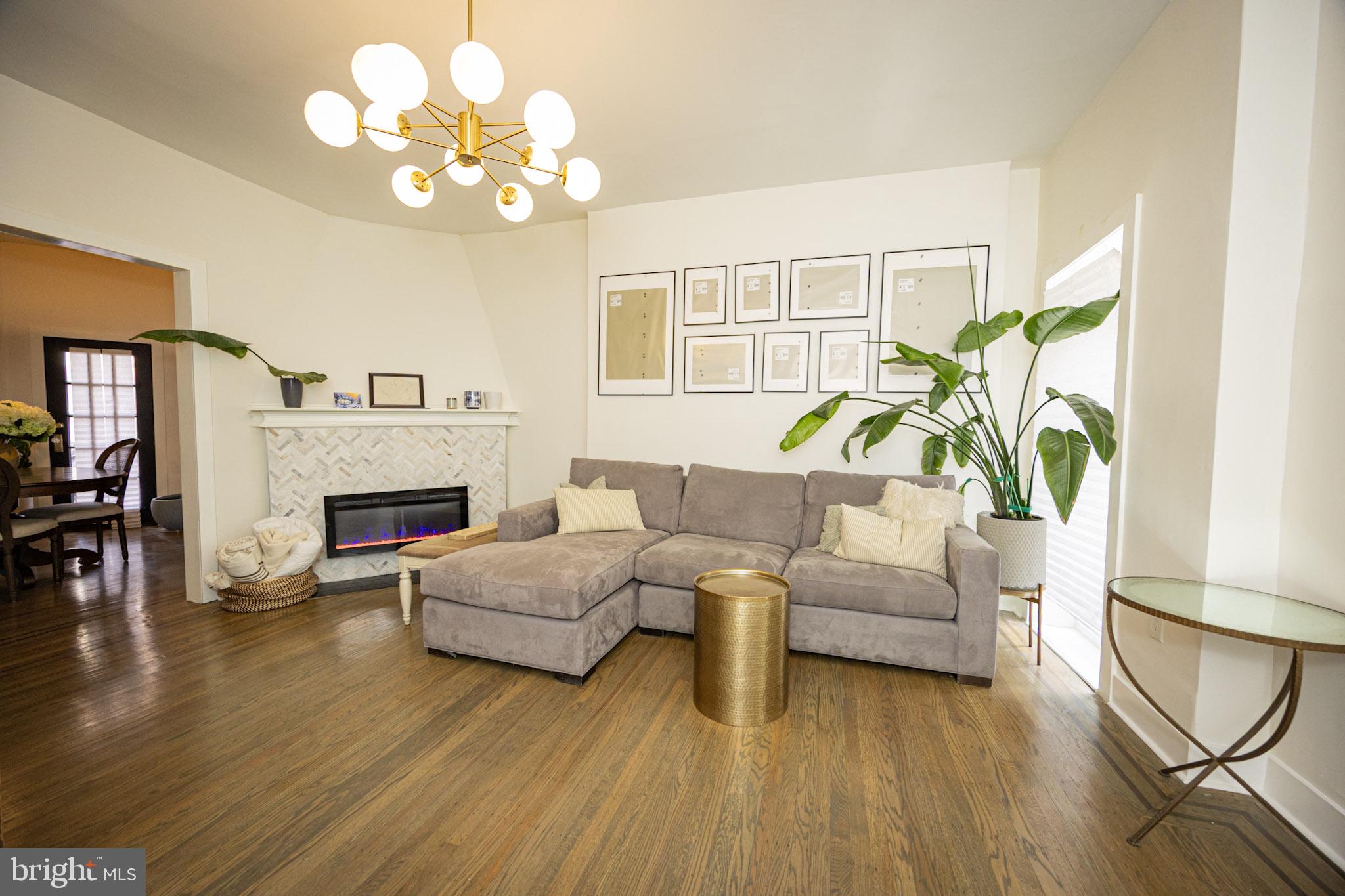 411 Vernon Road Philadelphia, PA 19119 - Photo 11 of 49 a living room with furniture a chandelier and a fireplace