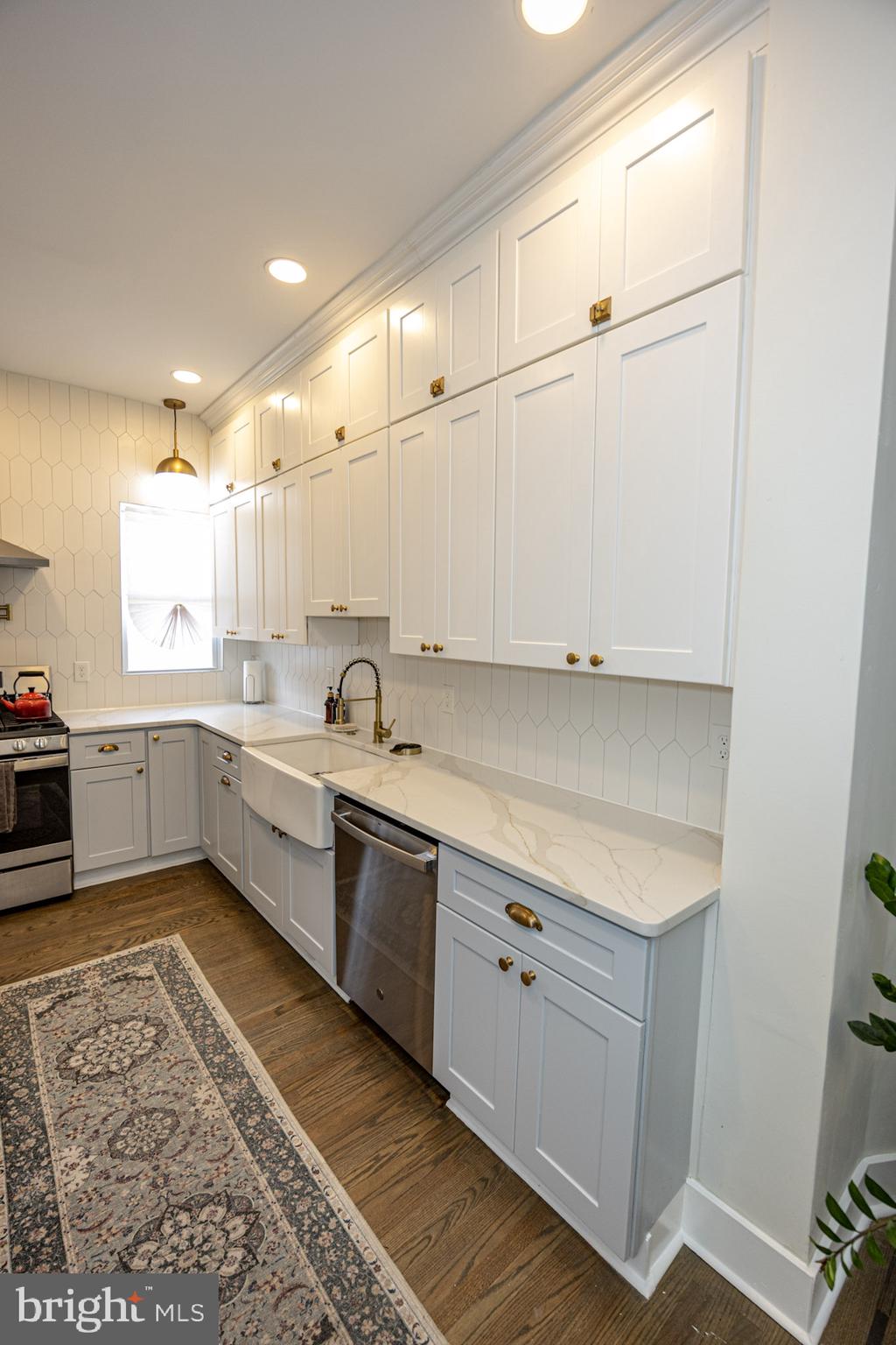 411 Vernon Road Philadelphia, PA 19119 - Photo 19 of 49 a large white kitchen with stainless steel appliances granite countertop a sink and cabinets