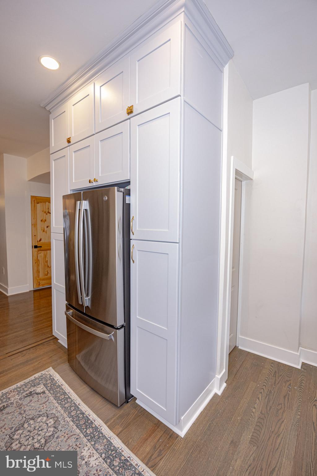 411 Vernon Road Philadelphia, PA 19119 - Photo 20 of 49 a view of a refrigerator in kitchen and an empty room with wooden floor