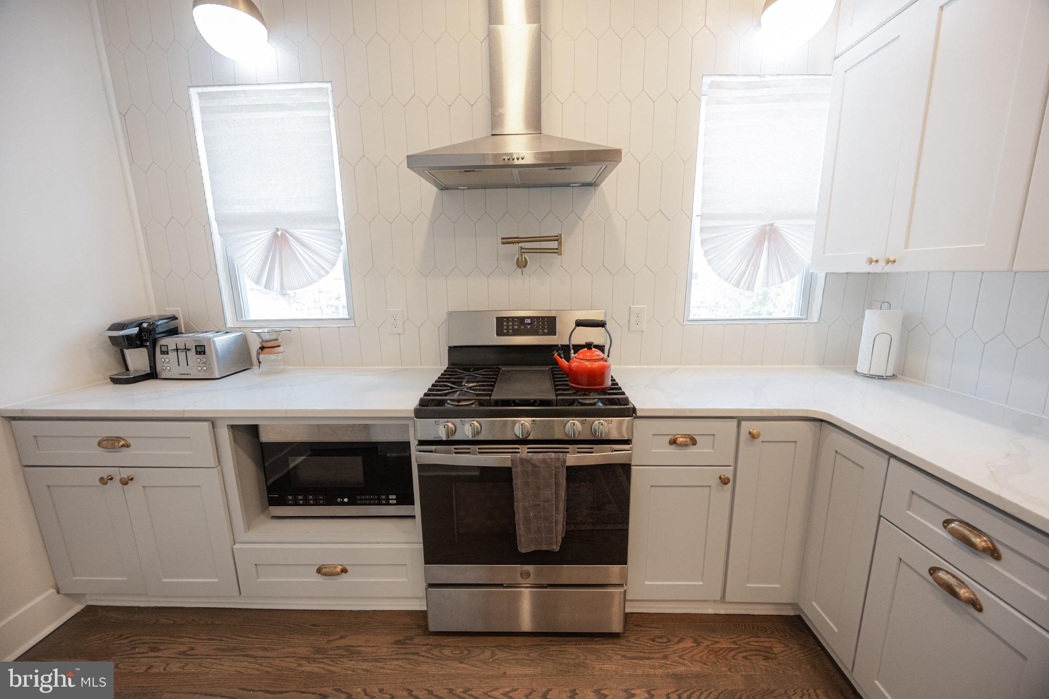 411 Vernon Road Philadelphia, PA 19119 - Photo 23 of 49 a kitchen with white cabinets and white appliances